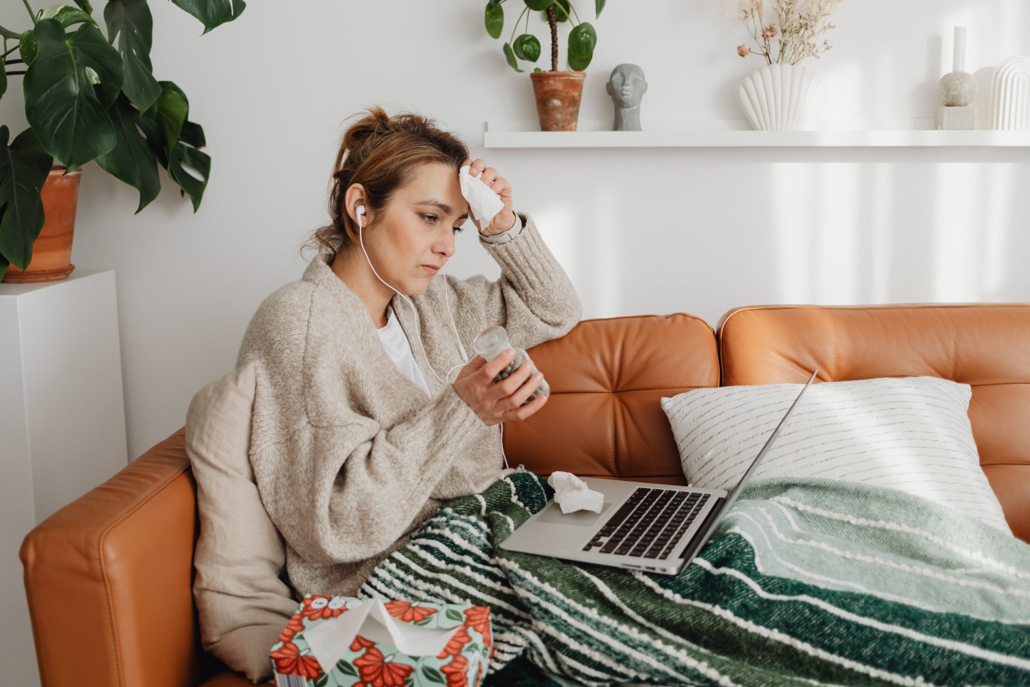Importance of Getting the Yearly Flu Vaccine 1 A sick woman on a couch using her laptop
